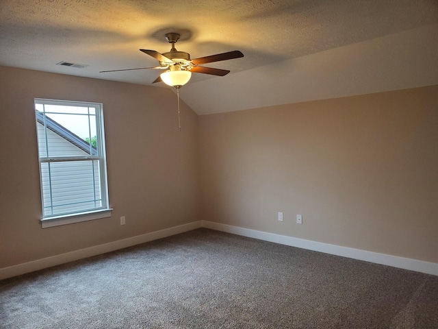 carpeted spare room with visible vents, baseboards, vaulted ceiling, a textured ceiling, and a ceiling fan