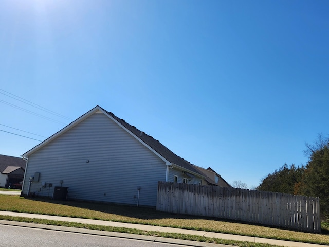 view of side of home featuring central AC unit and fence