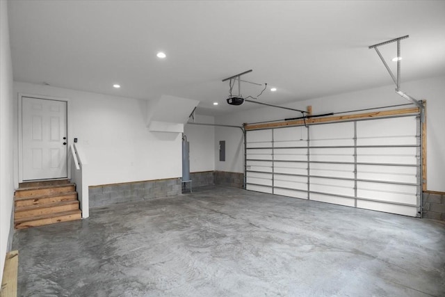 garage with electric panel, a garage door opener, and recessed lighting