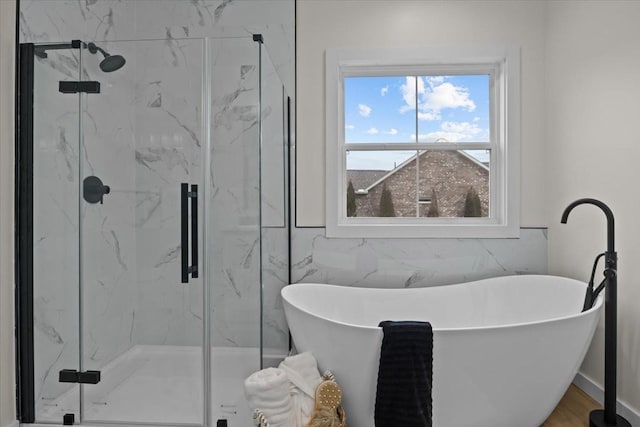 bathroom with a marble finish shower and a soaking tub