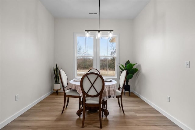 dining room featuring visible vents, baseboards, and light wood-style floors