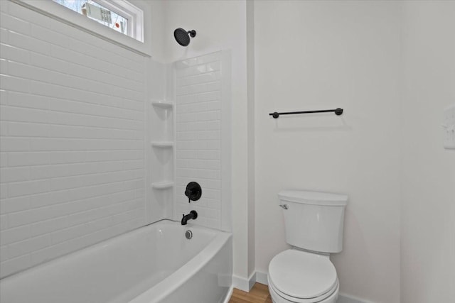 full bathroom with shower / tub combination, toilet, wood finished floors, and baseboards