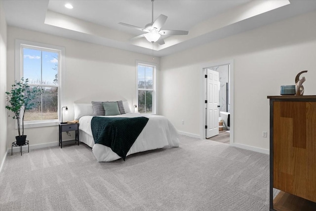 carpeted bedroom with a ceiling fan, a raised ceiling, recessed lighting, and baseboards