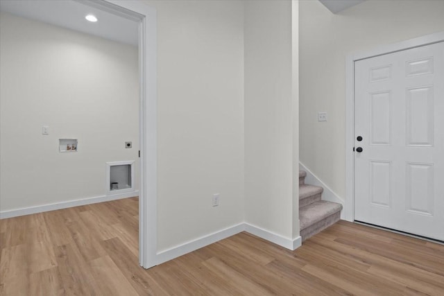 foyer entrance with light wood finished floors, stairs, and baseboards