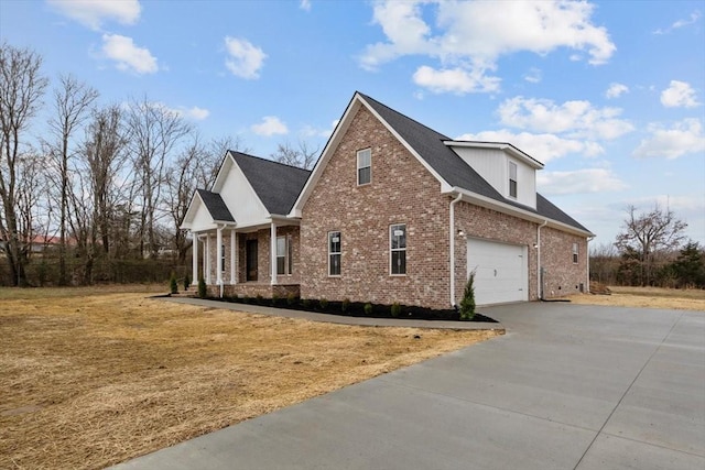 view of side of property featuring a garage, brick siding, and driveway