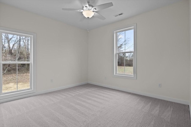 empty room with visible vents, carpet floors, and plenty of natural light