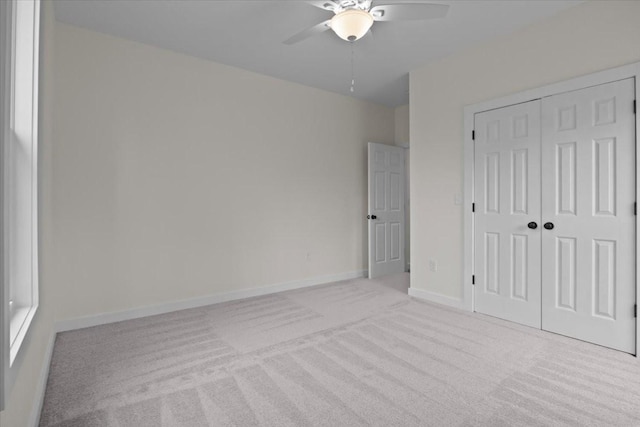 unfurnished bedroom featuring a ceiling fan, carpet, a closet, and baseboards