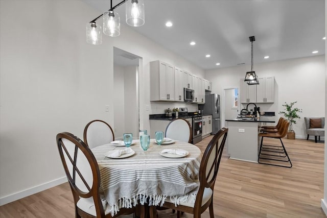 dining area with recessed lighting, light wood-type flooring, and baseboards