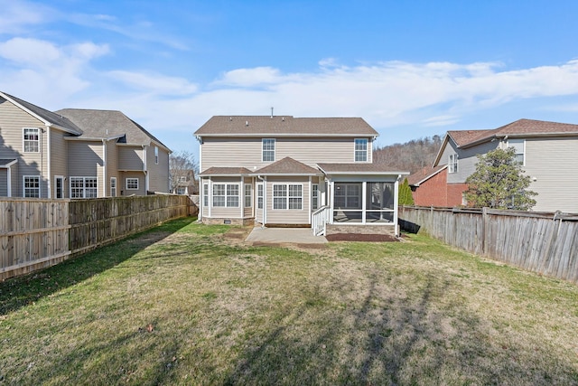 back of house featuring crawl space, a lawn, a fenced backyard, and a sunroom