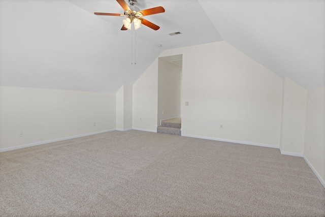 additional living space with visible vents, carpet flooring, baseboards, ceiling fan, and vaulted ceiling