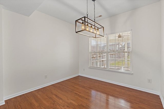 unfurnished dining area featuring visible vents, baseboards, and wood finished floors