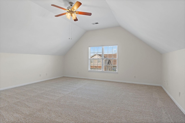 additional living space featuring visible vents, lofted ceiling, light colored carpet, and baseboards