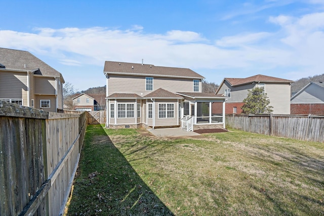 rear view of house with a fenced backyard, a patio, a yard, and a sunroom