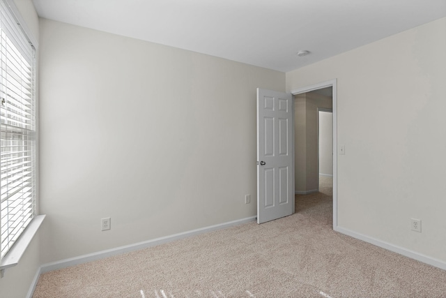 unfurnished bedroom with light carpet and baseboards