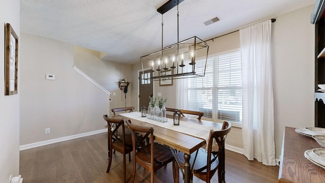 dining space featuring visible vents, baseboards, and wood finished floors