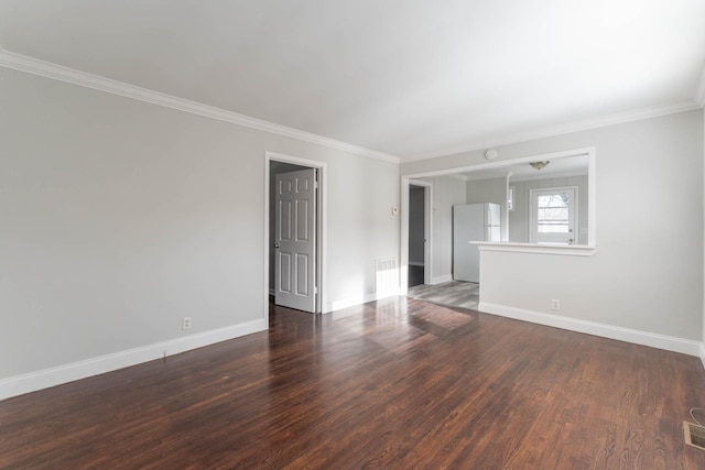 empty room featuring crown molding, baseboards, and wood finished floors