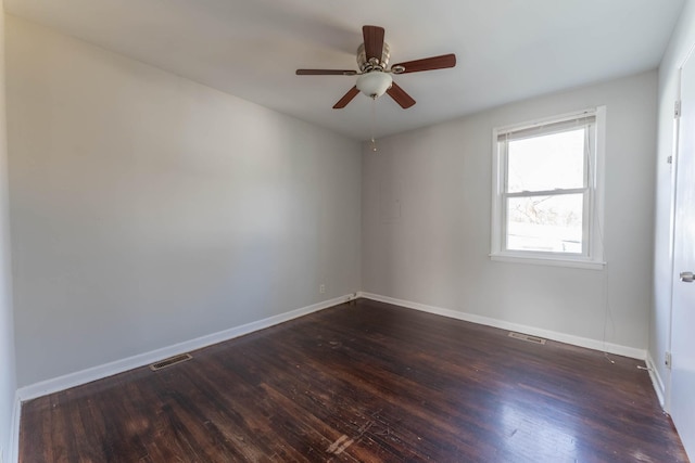 unfurnished room with dark wood finished floors, baseboards, and visible vents