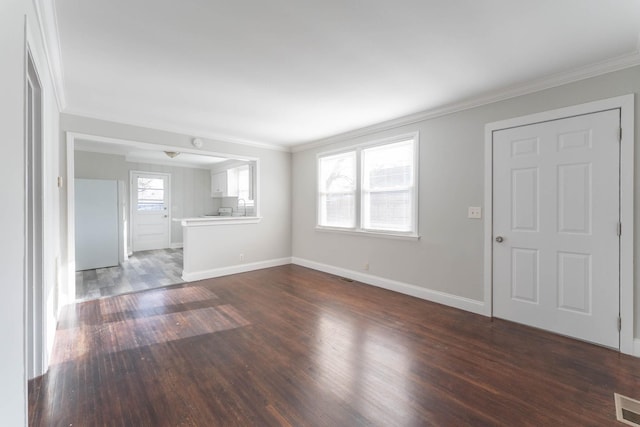 unfurnished living room featuring baseboards, dark wood-style flooring, and crown molding