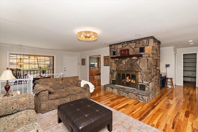 living area with baseboards, wood finished floors, and a fireplace