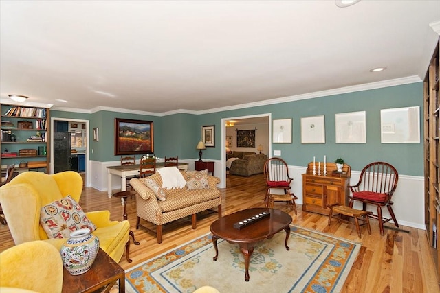 living room featuring recessed lighting, ornamental molding, wainscoting, and wood finished floors