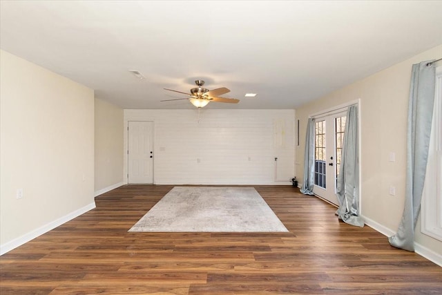 empty room featuring dark wood-style flooring, baseboards, visible vents, and ceiling fan
