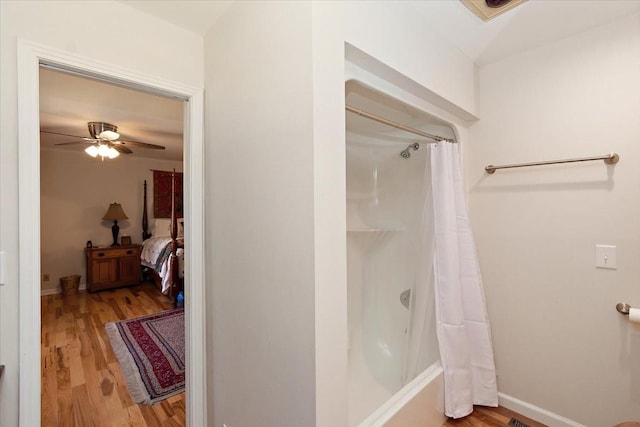 ensuite bathroom with shower / bath combo, a ceiling fan, ensuite bath, and wood finished floors