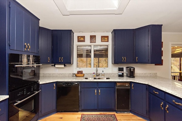 kitchen with light countertops, a sink, black appliances, and blue cabinets