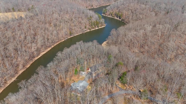 birds eye view of property featuring a water view and a wooded view