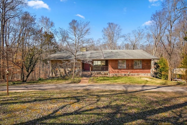 view of front of home featuring a front yard, covered porch, driveway, and a chimney