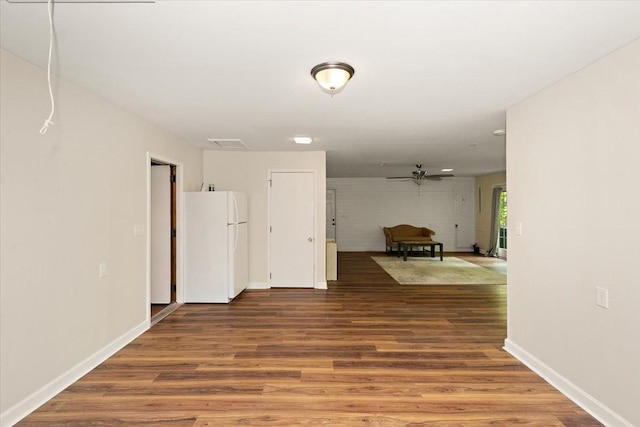 spare room with baseboards, a ceiling fan, wood finished floors, and visible vents