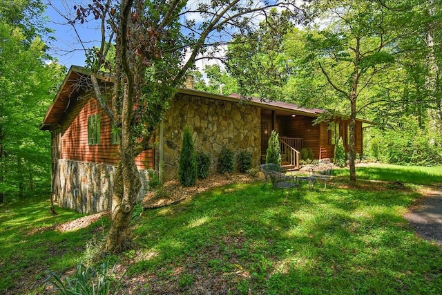 exterior space with a yard and stone siding