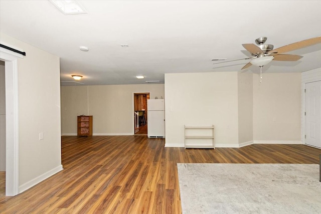 unfurnished living room with baseboards, ceiling fan, visible vents, and wood finished floors