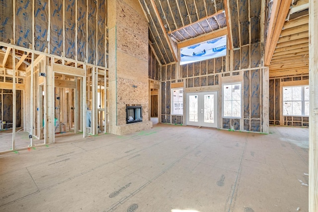 unfurnished living room with french doors and a towering ceiling