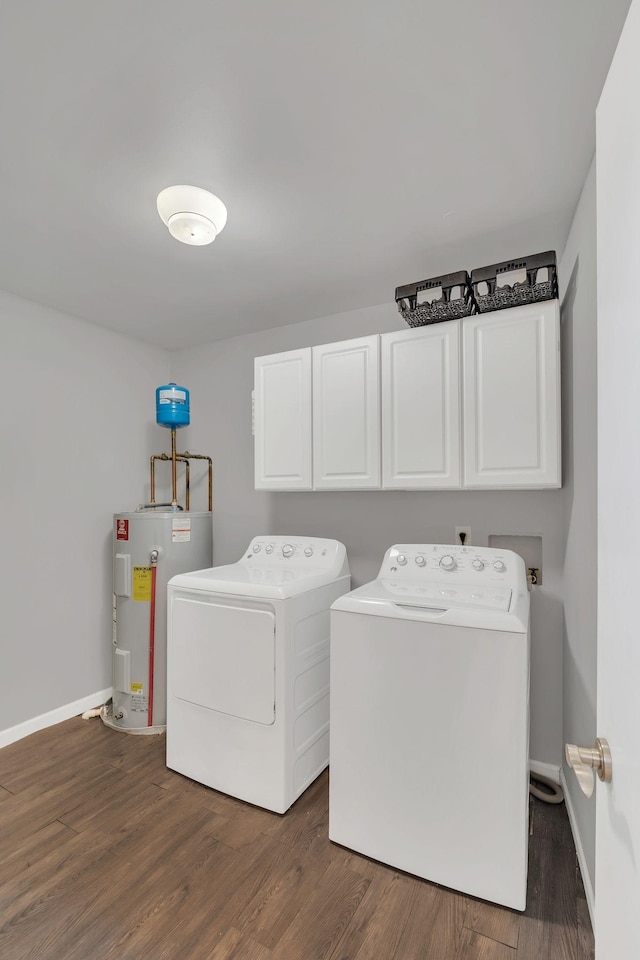 washroom with baseboards, washing machine and clothes dryer, cabinet space, dark wood-style flooring, and electric water heater