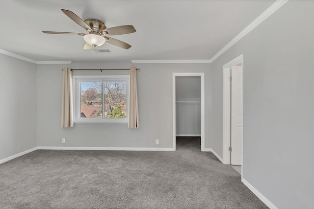 empty room featuring visible vents, carpet floors, baseboards, and ornamental molding