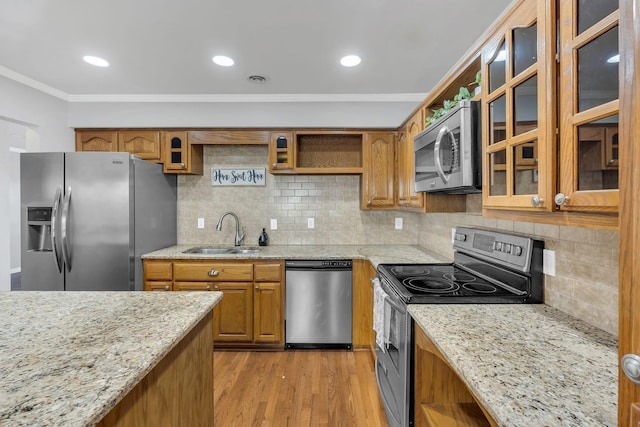 kitchen featuring a sink, stainless steel appliances, open shelves, and brown cabinetry