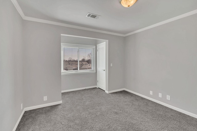 carpeted empty room featuring visible vents, baseboards, and crown molding