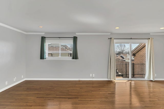 empty room featuring wood finished floors, baseboards, and ornamental molding