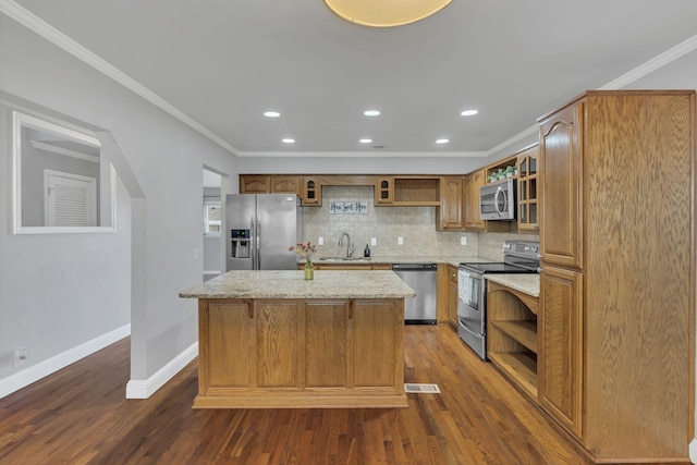 kitchen featuring open shelves, a center island, ornamental molding, appliances with stainless steel finishes, and a sink