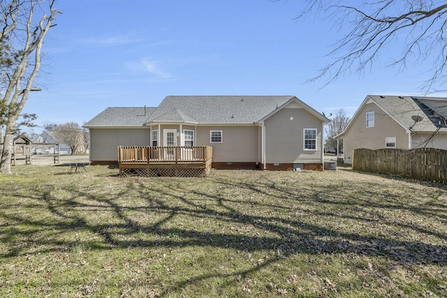 rear view of property with crawl space, a lawn, a deck, and fence