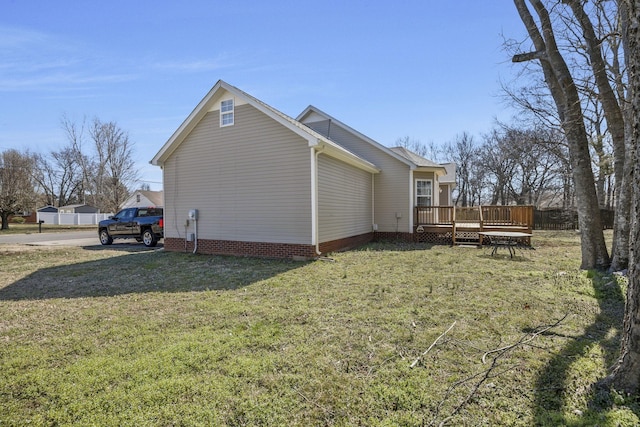 view of side of property featuring a yard and a wooden deck