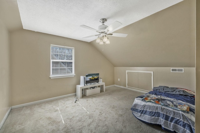 bedroom with carpet, baseboards, visible vents, vaulted ceiling, and a textured ceiling