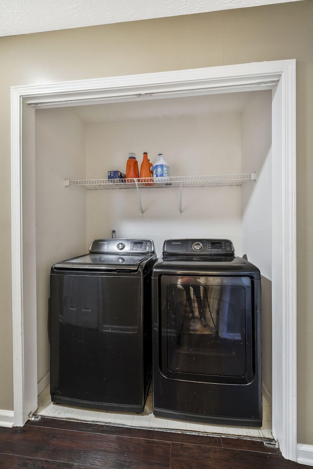 laundry area with laundry area, wood finished floors, baseboards, and washer and clothes dryer