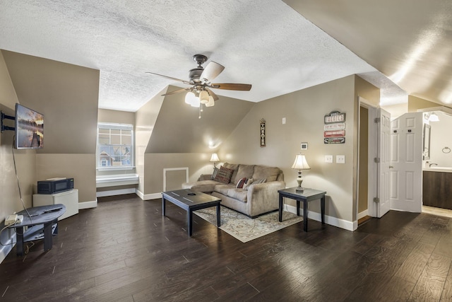 living area featuring hardwood / wood-style floors, a ceiling fan, baseboards, and a textured ceiling