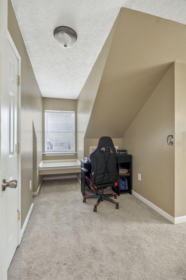 carpeted office with a textured ceiling, baseboards, and vaulted ceiling