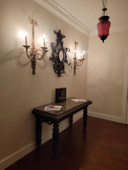 unfurnished dining area with baseboards, dark wood-style flooring, and ornamental molding