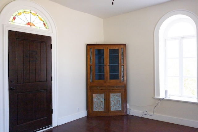 foyer entrance with dark wood finished floors and baseboards