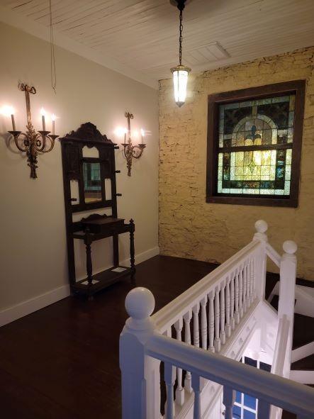 stairway featuring a chandelier, baseboards, and wood finished floors