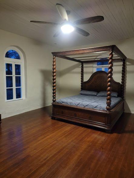 unfurnished bedroom with wooden ceiling, a ceiling fan, and wood finished floors