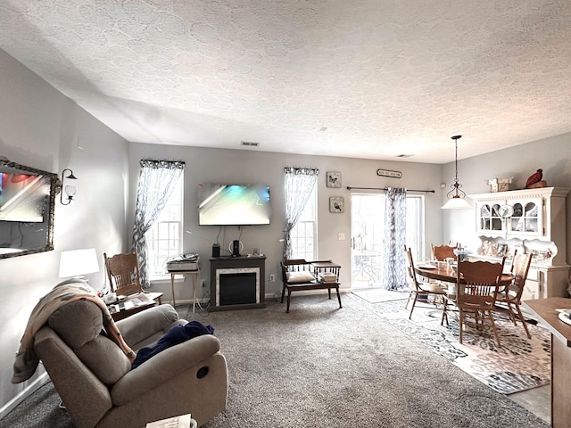 living room featuring carpet flooring, plenty of natural light, a fireplace, and visible vents